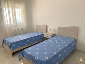two beds sitting in a room with at VILLA ARCANGELO Lo in Mandatoriccio Marina