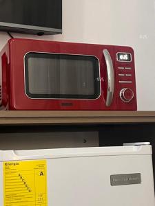a red microwave sitting on top of a refrigerator at HABITACION MODERNA CON PARQUEO y WIFI in Ambato