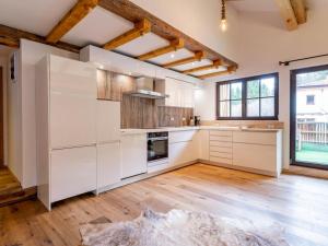 a kitchen with white cabinets and a wooden floor at Biber Art Apartment 1 Small in Biberwier +13 photos