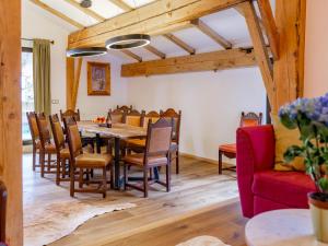 a dining room with a table and chairs and a red couch at Biber Art Apartment 1 Small in Biberwier