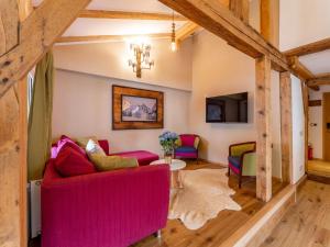 a living room with pink furniture and wooden beams at Biber Art Apartment 1 Small in Biberwier
