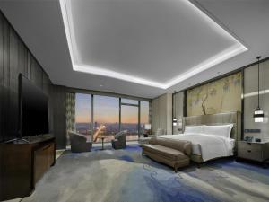 a bedroom with a bed and a flat screen tv at Hilton Zhuzhou in Zhuzhou +85 photos