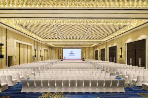 an empty hall with white chairs and a screen at Hilton Zhuzhou in Zhuzhou