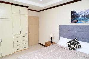 a bedroom with a large bed and white cabinets at Best E Villas St Silas St James in Saint James +29 photos