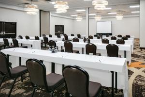 a conference room with white tables and chairs and a whiteboard at DoubleTree by Hilton Dallas Market Center in Dallas +30 photos