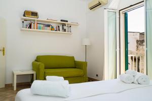 a bedroom with a green chair and a bed at La Torre e il Mare - Room 3 by StHey in Monopoli