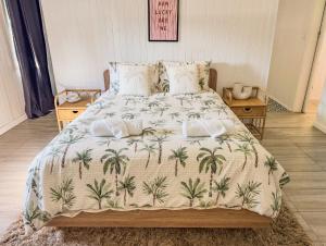 a bed with a blanket with palm trees on it at Panacea Rising in Yeppoon