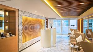 a lobby with a waiting area with chairs and tables at DoubleTree by Hilton Dubai Jumeirah Beach in Dubai
