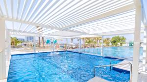 a large swimming pool with a white ceiling at DoubleTree by Hilton Dubai Jumeirah Beach in Dubai