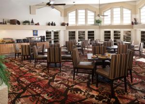a dining room with tables and chairs on a rug at Embassy Suites by Hilton Flagstaff in Flagstaff