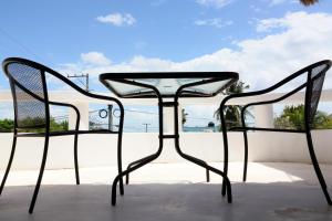 a glass table and two chairs on a patio at Hotel Maria Maria in Bacalar