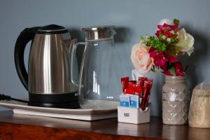 a coffee maker and flowers on a table at Hotel Maria Maria in Bacalar