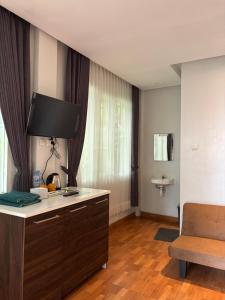 a room with a desk with a television and a chair at NK Villa Syariah And Cafe Prigen in Pasuruan