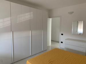 a white bedroom with a bed and a mirror at VILLA ARCANGELO Le in Mandatoriccio Marina