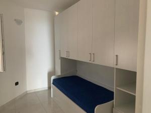 a small room with white cabinets and a blue mattress at VILLA ARCANGELO Le in Mandatoriccio Marina