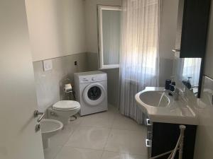 a bathroom with a washing machine and a washer at VILLA ARCANGELO Le in Mandatoriccio Marina