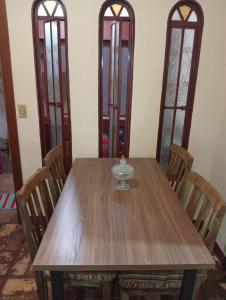 a wooden table with chairs and a glass bowl on it at Casa Duque in Ribeirão Preto