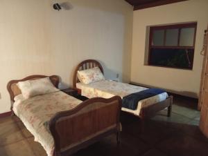 a bedroom with two beds and a window at Casa Duque in Ribeirão Preto