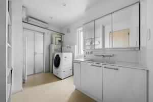 a kitchen with white cabinets and a washer and dryer at Mist in Sapporo