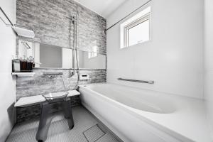 a white bathroom with a tub and a table in it at Mist in Sapporo