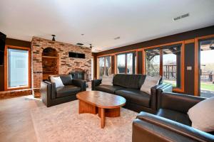 a living room with leather furniture and a brick fireplace at FC River Retreat in Wilson
