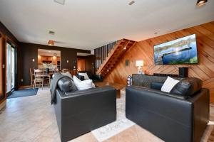 a living room with two black leather couches at FC River Retreat in Wilson