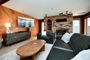 a living room with a couch and a brick fireplace at FC River Retreat in Wilson