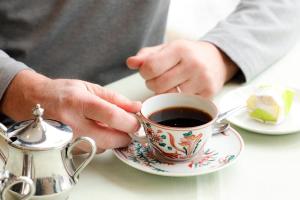 a person holding a cup of coffee on a table at Hotel Silk Inn Madarao in Iiyama +78 photos