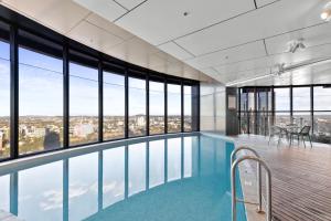 a swimming pool in a building with windows at Breathtaking City Views 1-Bed with Pool, BBQ & Gym in Brisbane