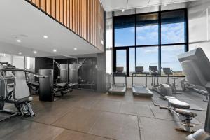 a gym with treadmills and machines in a building at Breathtaking City Views 1-Bed with Pool, BBQ & Gym in Brisbane