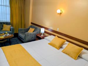a hotel room with a bed and two chairs at Hotel San Lázaro Arequipa - Cochera - Hotel en Arequipa in Arequipa