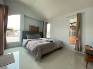 a bedroom with a large bed and a window at Gun Eng Resort กันต์เองรีสอร์ท in Ban Nong Nam Sang +12 photos