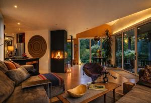 a living room with a couch and a table at Modern Glass House with Firepit, Views & Private Retreat in Elka Park
