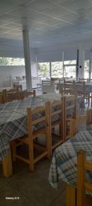 a room with a table and chairs and tables and windows at QUINTA CERRO LARGO Olavarria in Olavarría