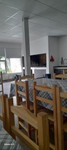 a dining room with a table and wooden chairs at QUINTA CERRO LARGO Olavarria in Olavarría