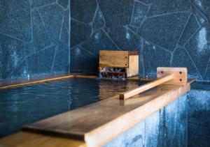 a pool of water with a wooden table in it at エンゼルグランヴィラ由布院 in Yufu