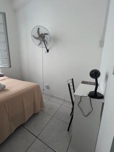 a room with a bed and a fan on the wall at Hostel Bahia POA Próx Shopping Total, Rodoviária e Hospital Presidente Vargas in Porto Alegre