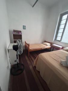 a room with two beds and a camera in it at Hostel Bahia POA Próx Shopping Total, Rodoviária e Hospital Presidente Vargas in Porto Alegre