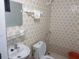 a bathroom with a toilet and a sink and a mirror at 2 CHAMBRES SALON MEUBLé in Yamoussoukro