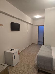 a room with a bed and a tv on a wall at Ideal Center in Nova Serrana
