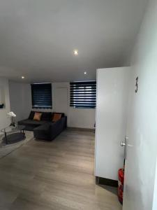 a living room with a black couch in a room at Chic Design and Modern Comfort - 1BR with Sofa Bed in Liège