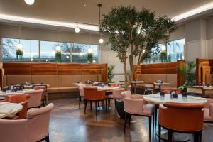 a restaurant with tables and chairs and windows at Hilton Glasgow in Glasgow
