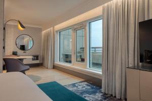 a hotel room with a bed and a large window at Hilton Glasgow in Glasgow