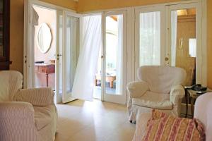 una sala de estar con sillas blancas y puertas correderas de cristal en Cul de Sac en Cariló