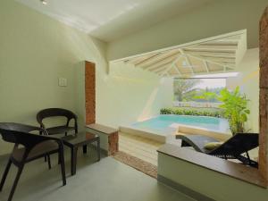 a rendering of a living room with a swimming pool at DoubleTree by Hilton Hotel Goa - Arpora - Baga in Baga