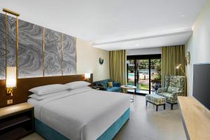a hotel room with a bed and a living room at DoubleTree by Hilton Hotel Goa - Arpora - Baga in Baga