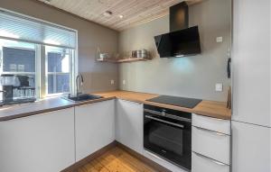 a kitchen with white cabinets and a sink and a microwave at 2 Bedroom Amazing Home In Slagelse in Slagelse