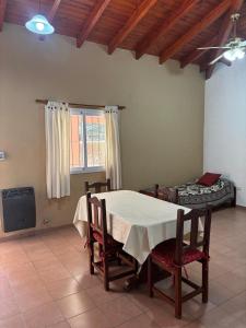 a dining room with a table and chairs and a bed at Piscoyaku Apart-Amplio parque con cancha de padel, voley y futbol in Potrero de los Funes