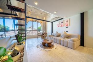 a living room with a couch and a table at Maison Boheme Modern Apartment & Villa with Pool in Sanur in Sanur +262 photos