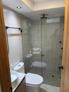 a bathroom with a toilet and a glass shower at Boreal House in Manizales +2 photos